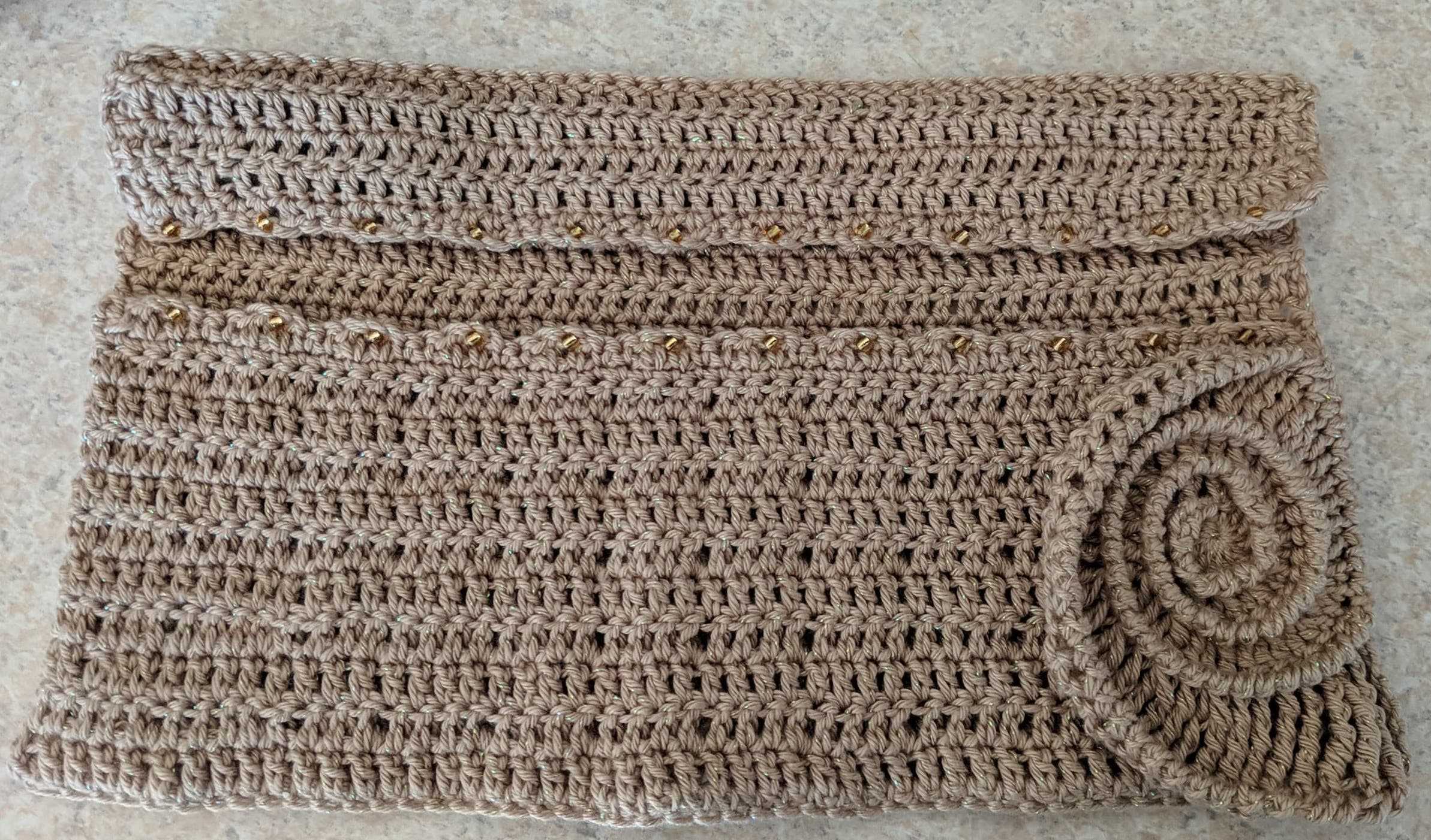 It's a holder for crochet hooks that rolls up and snaps under a button in the ammonite. It was my first time working with beads.